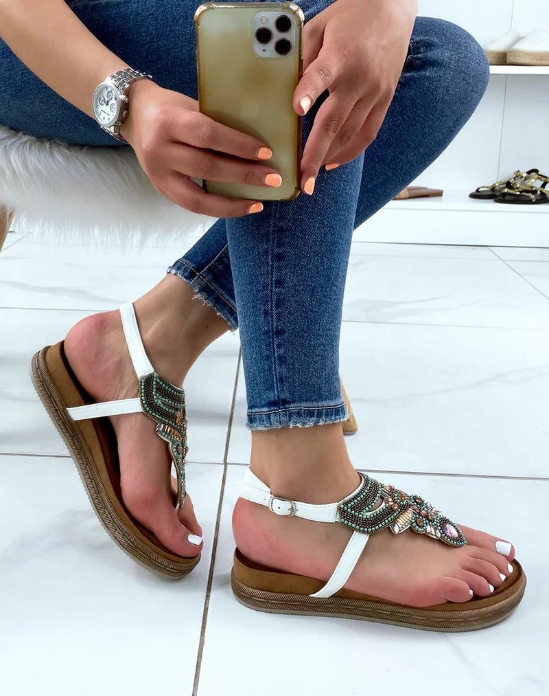Nu-pieds blancs à entre-doigt orné de bijoux bleus roses et dorés
