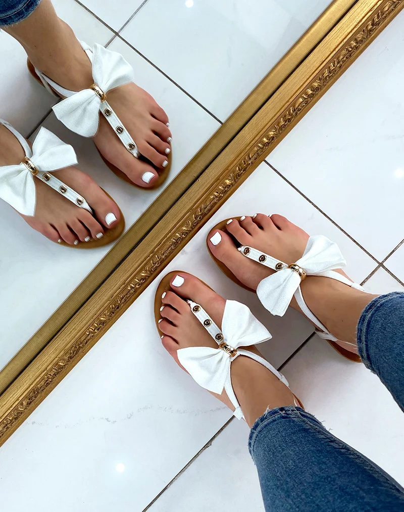Nu-pieds blancs à nœud et détails dorés