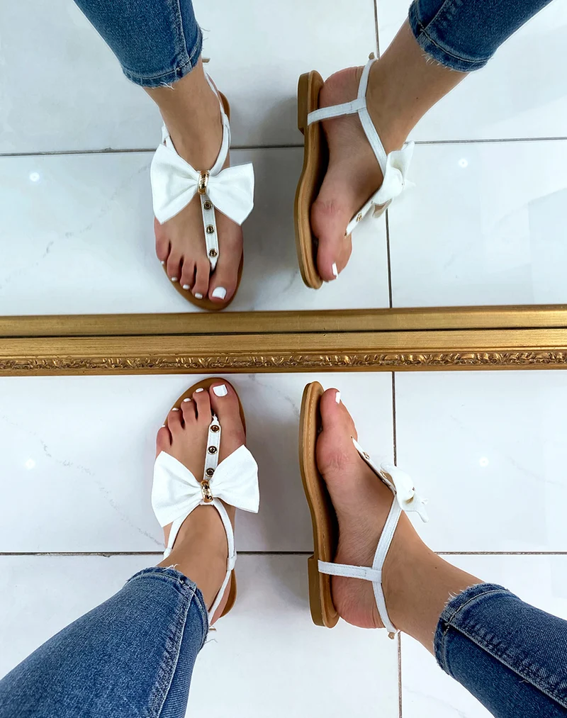 Nu-pieds blancs à nœud et détails dorés