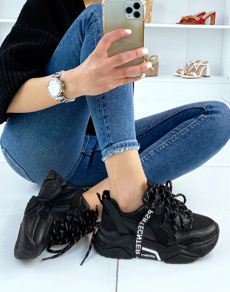 Baskets noires à grosse semelle et détails blancs