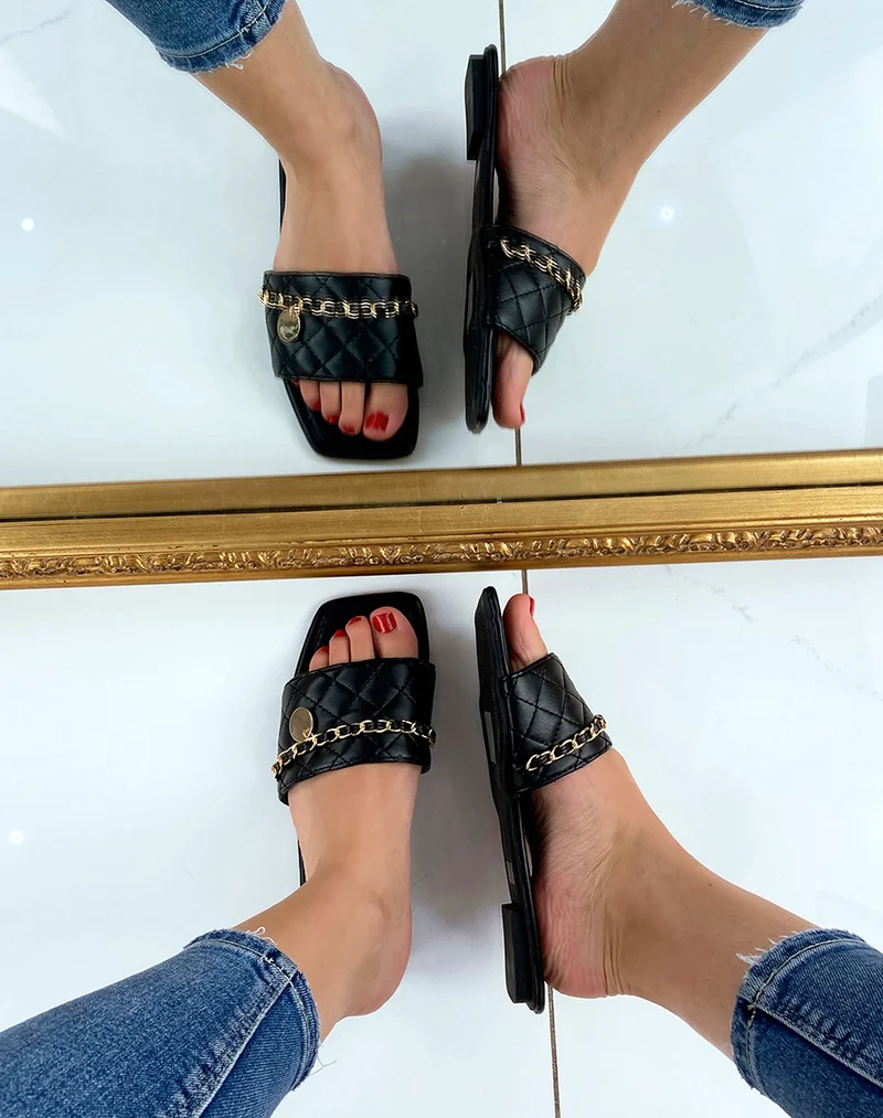 Mules plates noires matelassées à fine chaine dorée et bout carré