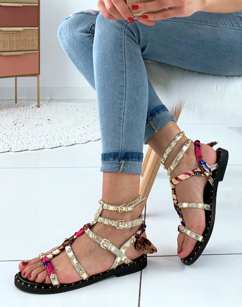Nu-pieds dorés à lanières ornées de clous avec détails foulard