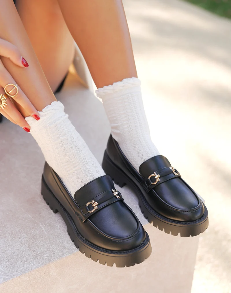 Mocassins femme noirs avec détail doré et semelle crantée épaisse
